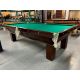 Table de billard usagée antique 9 x 4½ pieds de marque Brunswick Monarch avec ardoise naturelle 1 pouces d'épaisseur et fini Noir, tapis de billard rouge de marque Championship Invitational, poches en de style antique classiques en laiton et filet de cord